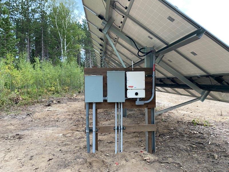 3 electrical boxes beneath a solar grid