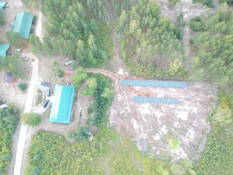 An aerial view of solar panels on a piece of land